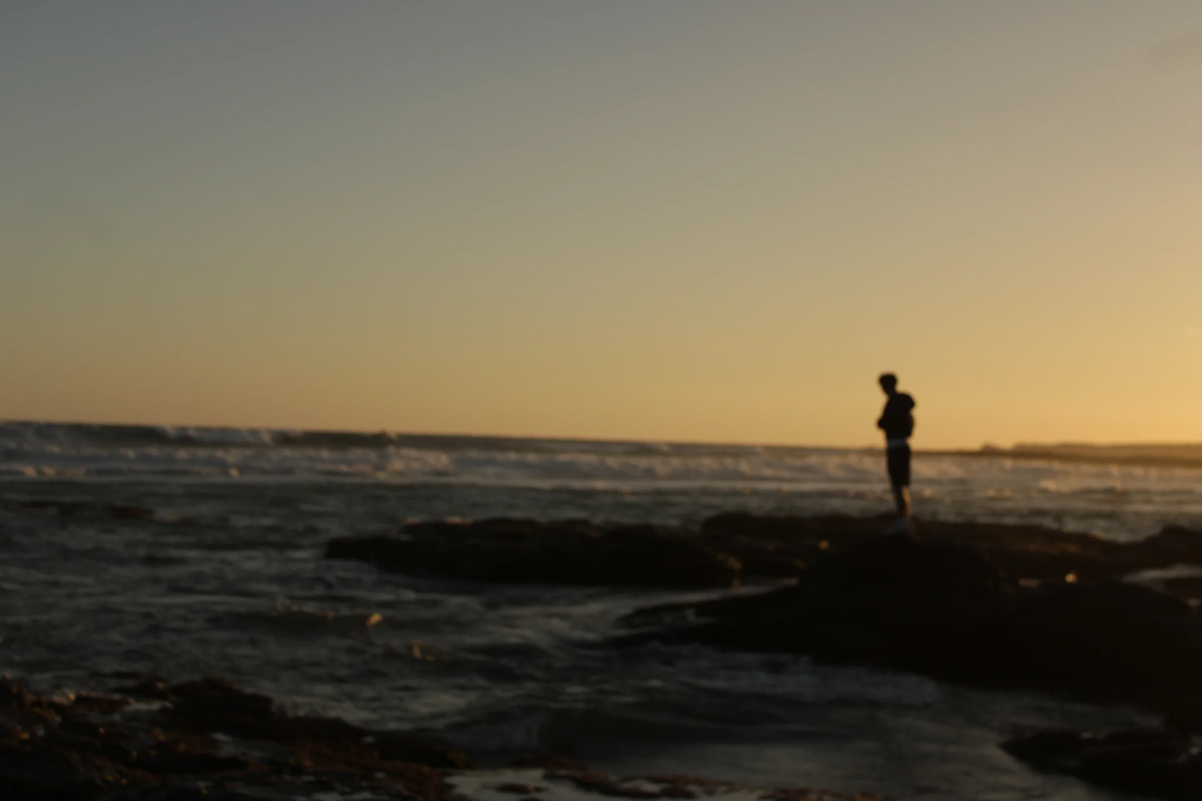 My mate (Matthew), standing on rocks staring out into the sea.